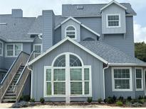 Charming multi-story condo complex showcasing a light blue exterior, white trim, and beautiful large windows at 4244 Sun Village Ct # 160, New Smyrna Beach, FL 32169