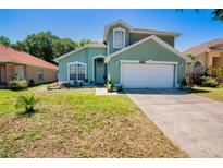 Charming two-story home with a lush green lawn, attached garage, and lovely curb appeal at 4381 Creekside Blvd, Kissimmee, FL 34746