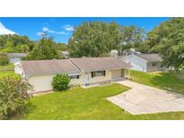Charming single story home featuring a well-manicured lawn, a long driveway, and lovely landscaping at 6426 Sw 60 Ave, Ocala, FL 34474