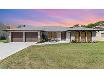 Charming single-story home featuring a brick facade, well-manicured lawn, and a cozy front patio at 71 Lazy Eight Dr, Port Orange, FL 32128