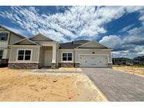 Charming single-story home with a two-car garage and beautiful stone accents at 873 Pointe Emerson Blvd, Apopka, FL 32703