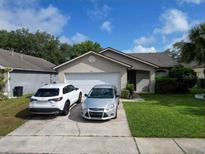 Charming single story home with a two car garage and a well-manicured lawn at 1567 Oak Hill Trl, Kissimmee, FL 34747