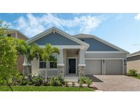 Charming single-Gathering home featuring a two-car garage, manicured lawn, and tasteful stone accents at 1908 Blissful Dr, Kissimmee, FL 34744