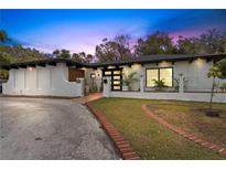 Charming single-story home with a white stucco exterior, dark trim, and manicured landscaping at 409 San Sebastian Prado, Altamonte Springs, FL 32714