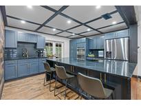 Modern kitchen with blue cabinets, granite countertops, stainless steel appliances and breakfast bar with seating at 409 San Sebastian Prado, Altamonte Springs, FL 32714