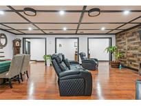 Spacious living room features hardwood floors, coffered ceiling, and comfortable black leather seating at 409 San Sebastian Prado, Altamonte Springs, FL 32714