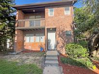 Charming two-story brick home featuring a balcony and well-maintained landscaping at 5126 Picadilly Circus Ct # 11, Orlando, FL 32839