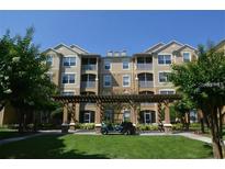 Beautiful condo with well-manicured lawn and a golf cart in the covered area in front of the building at 6434 Cava Alta Dr # 303, Orlando, FL 32835
