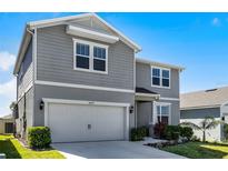 Charming two-story home with a two-car garage and meticulously manicured landscaping at 7649 Ragusa Way, Clermont, FL 34714