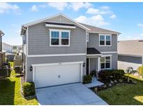 Stylish two-story home with landscaped front yard and attached two-car garage in a great neighborhood at 7649 Ragusa Way, Clermont, FL 34714