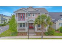 Charming two-story home with red doors, a manicured lawn, and a mature palm tree in a desirable neighborhood at 7831 Dausset St, Orlando, FL 32827