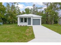 Charming single-Gathering home with a well-maintained lawn and a gray front door and garage at 2259 3Rd Ave, Deland, FL 32724