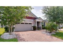 Charming home featuring a brick driveway, well-manicured landscaping, and a two-car garage at 2331 Kennington Cv, Deland, FL 32724