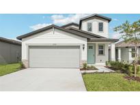 Charming two-story home with a two car garage, landscaped yard, and a light blue front door at 2774 Virginia Pine Dr, Bartow, FL 33830