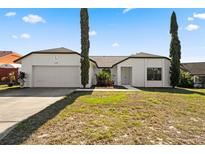 Charming single-story home showcasing a well-manicured lawn and a two-car garage at 1135 Marni Ridge Ct, Kissimmee, FL 34747