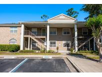 Attractive two-story condo building with stairs, columns, and reserved parking at 133 Reserve Cir # 109, Oviedo, FL 32765