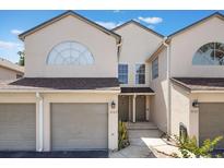 Inviting townhome showcasing a well-maintained front exterior with neutral tones, attached garage, and neat landscaping at 3004 Cottage Grove Ct # 1805, Orlando, FL 32822