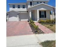 Charming two-story home featuring a well-manicured lawn and a brick driveway leading to a two-car garage at 3725 Blue Mountain Way, Apopka, FL 32712