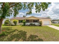Charming single-story home with a well-manicured lawn, mature trees, and an attached garage at 6366 Sw 115Th Street Rd, Ocala, FL 34476