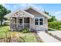 Charming single-story home featuring a cozy front porch with stone accents and a well-maintained lawn at 720 N 6Th St, Haines City, FL 33844