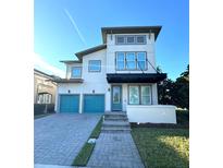 Contemporary two-story home featuring a blue garage door, stylish entrance, and a well-manicured lawn at 8140 Mistral Dr, Orlando, FL 32827