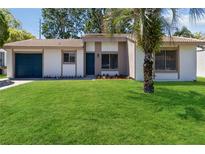 Charming single-story home featuring a well-manicured lawn and a lovely, mature palm tree at 10665 Whitman Cir, Orlando, FL 32821