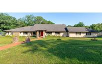 Sprawling ranch-style home featuring a well-manicured lawn and a red brick walkway leading to the front door at 117 Orange Ridge Dr, Longwood, FL 32779