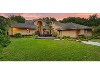 Charming home with manicured lawn, deck, and inviting entryway at sunset at 1555 Waterwitch Dr, Orlando, FL 32806