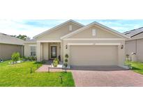 Charming single Gathering home with a two car garage and well maintained lawn at 209 Hamlet Loop, Davenport, FL 33837