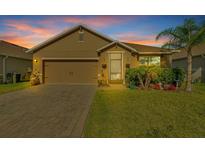 Charming single-story home with brick driveway, well-maintained lawn, and mature palm tree at 424 Lazio Cir, Debary, FL 32713