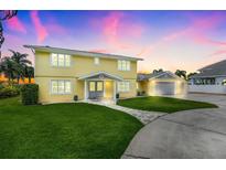 Bright yellow two-story home featuring a spacious lawn at sunset at 5224 Saint Regis Pl, Belle Isle, FL 32812