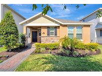 Charming single-story home with a stone facade, manicured lawn, and inviting front porch at 9456 Komika Ln, Winter Garden, FL 34787
