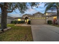 Charming single-story home featuring a well-manicured lawn, two-car garage, and beautiful landscaping at 9736 Heron Pointe Dr, Orlando, FL 32832