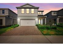 Charming two-story home with a brick driveway and lush landscaping at 10215 Park Estates Ave, Orlando, FL 32836