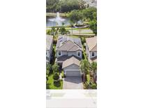 Stunning aerial view of home showcasing solar panels, landscaping, and water view with fountain at 1090 Wildmeadow Run, Winter Park, FL 32792