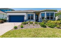 Charming single-story home featuring a well-manicured lawn, beautiful landscaping, and a two-car garage at 13828 Tybee Beach Ln, Orlando, FL 32827