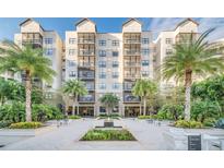 Beautiful exterior view of a multi-story condo building with tropical landscaping and a central water feature, creating an inviting atmosphere at 14501 Grove Resort Ave # 2103, Winter Garden, FL 34787