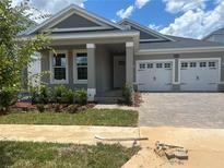 Charming single-Gathering home featuring a two-car garage, well-manicured lawn, and inviting front porch at 16759 Muskgrass Dr, Winter Garden, FL 34787