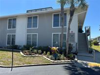 Inviting condo exterior with gray siding, well-manicured landscaping, and a charming staircase leading to the upper units at 1935 Conway Rd # T6, Orlando, FL 32812