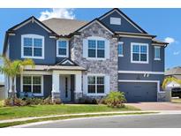 Beautiful two-story home with stone accents, gray siding, and a well-manicured lawn at 2628 Cedar Shake Ct, Oviedo, FL 32765