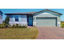 Charming single-story home with light blue shutters, front door, and a brick driveway at 264 Towns Cir, Haines City, FL 33844