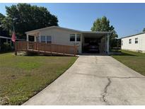 Inviting single-story home featuring a ramp, covered parking, and a well-maintained lawn at 2650 Einwood Dr, Kissimmee, FL 34758