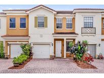 Charming townhome with a brick driveway, attached garage and colorful landscaping at 3462 Allegra Cir, St Cloud, FL 34772