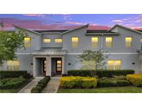 Charming townhome with a modern facade, red door, covered entry, and professionally landscaped front yard at 368 Ocean Course Ave, Davenport, FL 33896