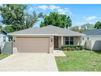 Charming single-story home with a well-manicured lawn, brick driveway, and an attached two-car garage at 3723 Broadway St, Gotha, FL 34734