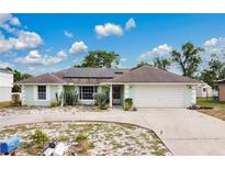 Charming one-story home with a circular driveway and solar panels on the roof at 432 Taylorville St, Deltona, FL 32725
