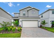 Charming two-story home featuring manicured landscaping and a paved driveway at 1293 Emerald Row, Clermont, FL 34714