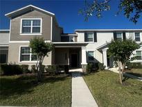 Charming townhouse with a well-manicured lawn and a welcoming entryway under a bright blue sky at 14143 Title Way, Winter Garden, FL 34787