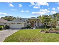 Charming single-story home with a well-manicured lawn, arched windows, and a two-car garage at 58 Golf View Dr, Ocala, FL 34472
