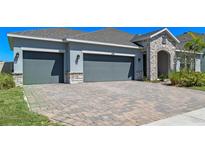 Beautiful single-story home featuring a three-car garage and a brick-paved driveway, offering both convenience and curb appeal at 690 Blue Citrus Ln, Minneola, FL 34715
